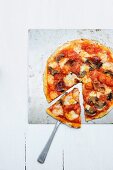 A tomato, ham, cheese and mushroom pizza
