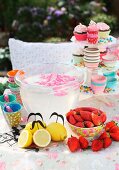 Colourful, edible decorations for garden party on table with floral tablecloth
