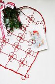 Red, wire ornamental heart with clips for displaying Christmas cards