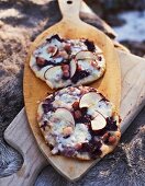 Mini pizzas topped with red cabbage, apple, cheese and bacon