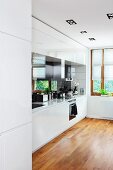 weiße Einbauküche mit Parkettboden in modernem Ambiente, kardanische Einbaustrahler an Decke