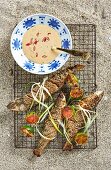 Grilled grey mullet with a sesame seed coating served with peanut sauce