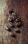 Dark organic coffee beans on a wooden surface