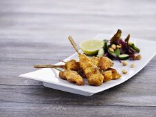 Breaded chicken skewers with peanuts