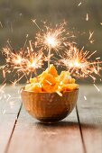 Honeycomb in a copper bowl decorated with sparklers, England