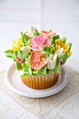 A cupcake decorated with romantic sugar flowers