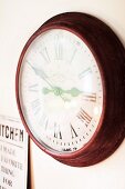 Round wall clock with antique-style Roman numerals