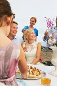 Couple making a toast with group of friends at wedding reception