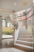 Weisser Treppenaufgang mit Wendeltreppe & Dekoobjekt aus Kugeln in Luxus-Hotel