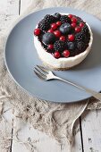 A mini cheesecake with blackberries, blueberries and redcurrants