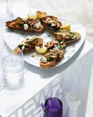 Bruschetta topped with mushrooms and spinach and served with lemon slices