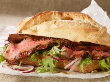 A grilled steak sandwich on parchment paper