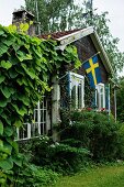 Rustic wooden house with Swedish flag on terrace