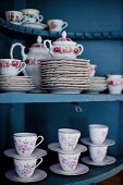 Floral crockery in blue cabinet