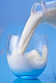 Milch aus Flasche in ein Glas gießen