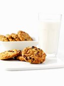 Three Oatmeal Raisin Cookies on a Green Plate with a Glass of Milk