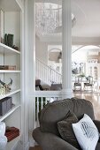 Armchair next to shelves and in front of white balustrade with white column