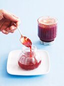 Strawberry jam being transferred into a jar