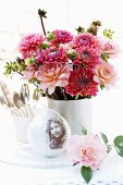 Nostalgic arrangement with vase of dahlias & snow globe on table