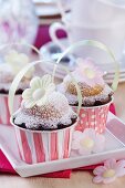 Spring muffins decorated with rice paper flowers in paper cases with handles