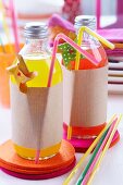 Limonadenflaschen dekorativ umwickelt mit Packpapier auf Filzuntersetzern