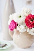 Cream narcissus and ranunculus in pale stoneware jug