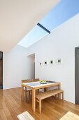 Wooden table and bench set below skylight