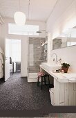 DIY washstand made from pale wood, marble pebble floor and shower cubicle with rainfall shower in loft-apartment bathroom