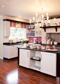 Black and white fitted kitchen with striped Roman blind and pink splashback