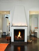 Lanterns on mantelpiece above fire in open fireplace flanked by open doors