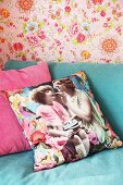 Scatter cushion with vintage photo print on turquoise sofa against pink floral wallpaper