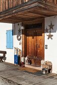 Sledge, lanterns and star-shaped decorations around front door of old Italian chalet