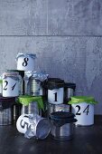 Hand-crafted Advent calender made from tin cans with tissue paper lids
