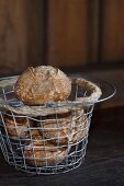 Homemade wholemeal rolls in a wire basket