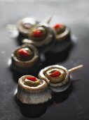 Anchovy rolls with olives on cocktail sticks