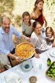 Familie isst zusammen im Garten