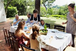 Familie isst zusammen im sommerlichen Garten