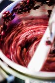 Read grapes being puréed in a food mill