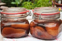 Two jars of pears in cherry brandy outside