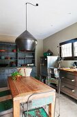 Holztisch und Edelstahlschränke in einer Küche mit Vintage Interieur