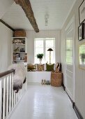 White, wood-clad landing with balustrade and window seat