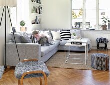 Kleine Kinder auf grauem Polstersofa in modernem Wohnzimmer mit skandinavischem Flair