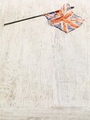 A British flag on a white wooden surface