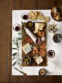 Wurstplatte mit Käse, Prosciutto, Oliven, Brot, Mandeln, Marmelade und Rotwein