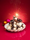 Chocolate meringues with chocolate sauce and a sparkler for Christmas