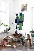 Wand-Collage aus Stoffresten in Grüntönen und Kleinmöbel in skandinavischer Altbauwohnung