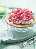 A mini shortbread cake topped with whipped cream and rhubarb