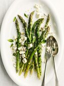 Grilled green asparagus with sheep's cheese and cutlery