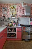 Eclectic kitchen with floral wall, Spanish posters and pink-painted cabinets