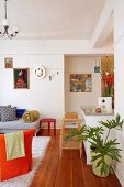 Retro interior with white kitchen counter, grey chaise and orange armchair